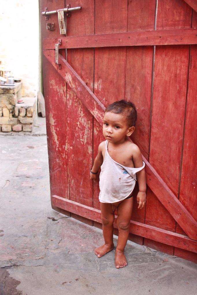 little boy in front of door in Kachhpura, India