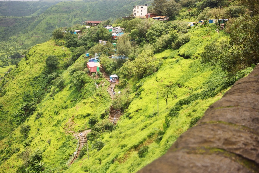 Little houses on a bright green hill outside Lonavala, India