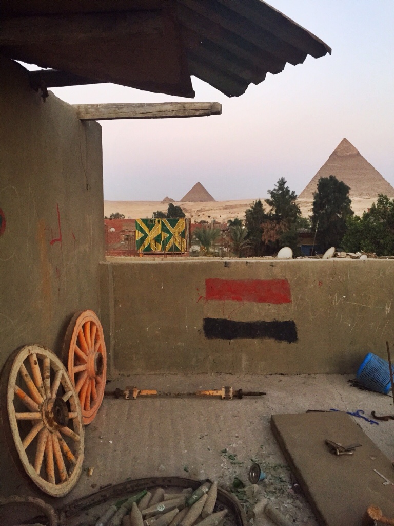Rooftop, painted Egyptian flag, Pyramids of Giza. 